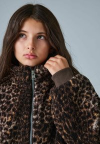 Braun und beige Leopardenmuster-Fleecejacke mit hohem Kragen, einem Reißverschluss vorne und gerippten braunen Bündchen. Weiches, strukturiertes Material.