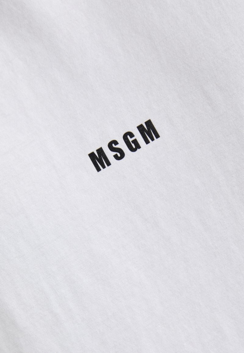 White cotton t-shirt with a round neckline, featuring the brand name "MSGM" in bold black letters positioned centrally. Smooth texture.