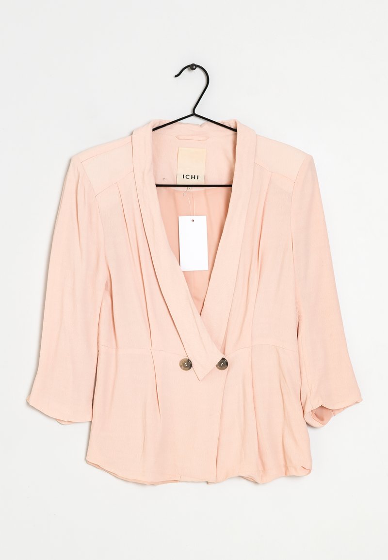 Vaaleanpunainen, kevyt takki, jossa on kietaisumalli, napitus, pitkät hihat ja kaksi etunappia. Takki on pehmeää materiaalia ja minimalistisella designilla.