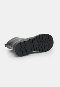 Stivale di gomma nero con suola texture. Presenta una superficie liscia, punta arrotondata e una linguetta sul tallone per facilitare l'indossamento.