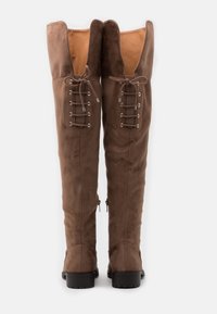 Brązowe zamszowe kozaki za kolano z głębokim dekoltem w kształcie litery V, ozdobione dekoracyjnymi sznurówkami i srebrnymi oczkami po bokach, z teksturowaną czarną podeszwą.