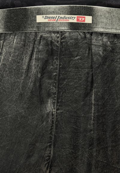 Тъмно сива деним материя с метален сребърен колан, обозначен с Diesel Industry Denim Division на черен и червен текст.