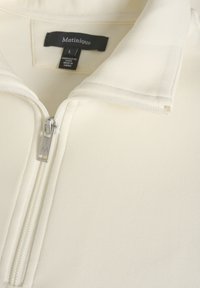 Crème-kleurige zip-up pullover met een staande kraag en een fijne textuur. Beschikt over een zilveren rits met een logo-trekkoord en tag-details aan de binnenkant.