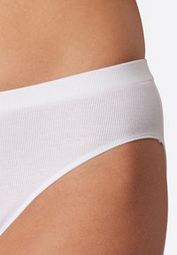 Mutande bianche in cotone a coste con una cintura elastica liscia, caratterizzate da un design minimalista e bordi senza cuciture per una vestibilità aderente.
