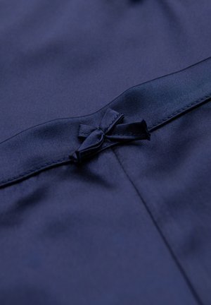 Tissu bleu marine à texture lisse avec un petit détail en nœud à la taille, accentué par une finition satinée.