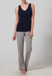 Marineblå ermeløs topp med V-hals og grå pysjbukser. Toppen er tettsittende; buksene er løse med elastisk midje. Myk bomullsblanding.