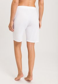 Witte katoenen shorts met een elastische tailleband, midden-dij lengte, gladde textuur en geen zichtbare patronen of extra kenmerken.