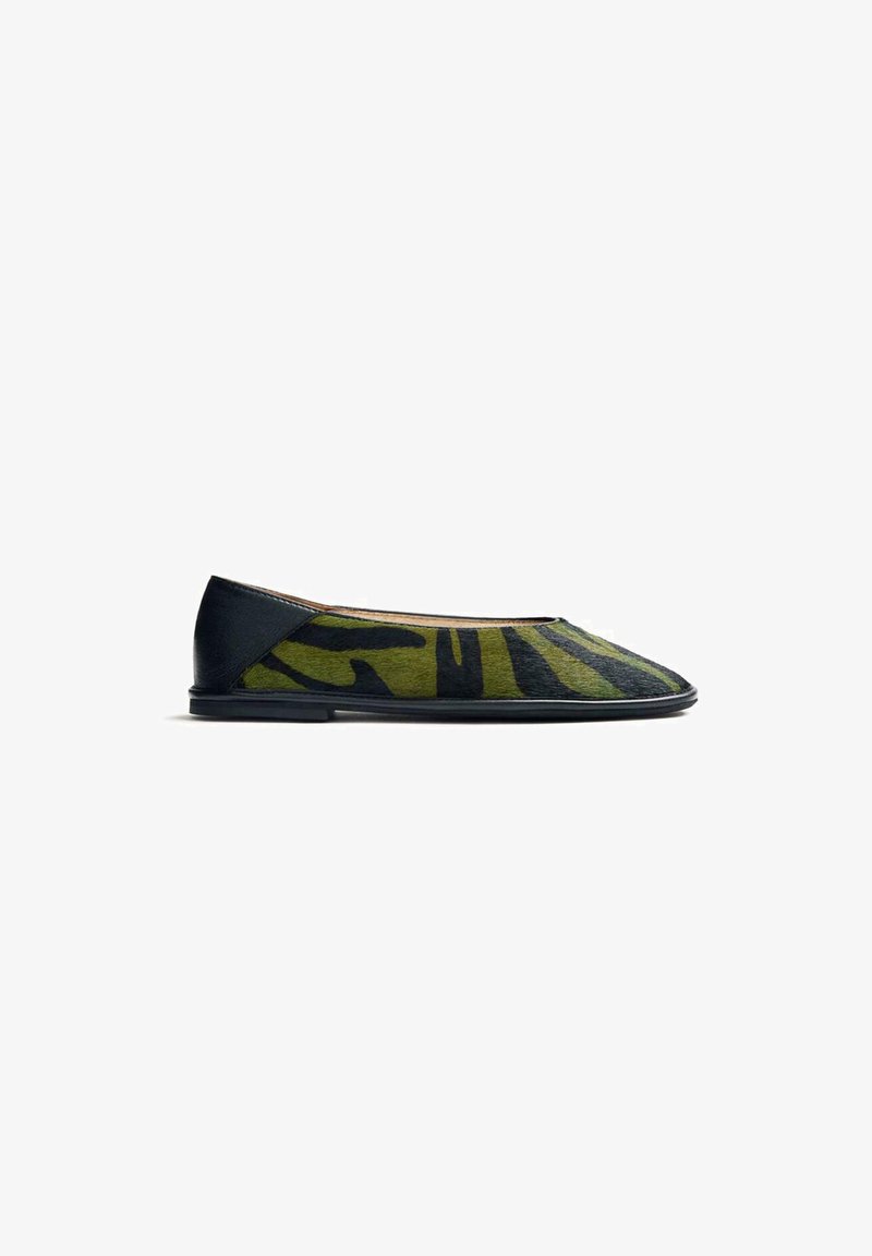 Ballerina con un motivo camouflage verde e nero, rifiniture in pelle, forma aerodinamica e suola nera sottile. Dettaglio di superficie testurizzata.