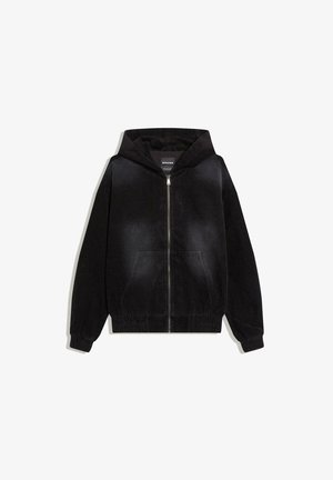 Felpa nera in velluto a coste con zip, tasche frontali, polsini ed orlo elasticizzati e cappuccio attaccato, distesa su uno sfondo bianco.