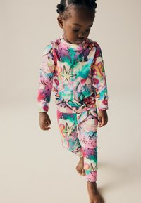 Ensemble de pyjama coloré à manches longues avec un imprimé graphique éclatant dans des tons de rose, bleu et violet ; fabriqué en tissu doux et extensible.