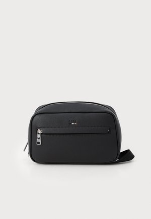 Bolso de cuero sintético negro con una superficie texturizada, un bolsillo frontal con cremallera y un zipper plateado. Presenta una forma rectangular y una correa lateral.