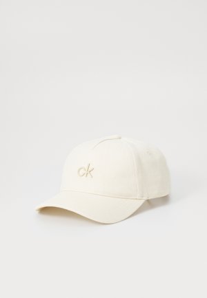 Krém színű baseball sapka, puha anyagból készült. Az elején hímzett "ck" logó található, valamint ívelt napellenző.