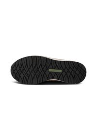 Semelle extérieure en caoutchouc noir avec un motif de traction texturé. Semelle intermédiaire de couleur crème et tige marron avec des accents subtils. Design durable et fonctionnel.
