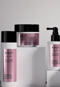 KIKO Nourish & Protect sjampo, hårmaske og hårspray med rosa detaljer på hvite beholdere. Elegant design med svarte hetter og pumper.