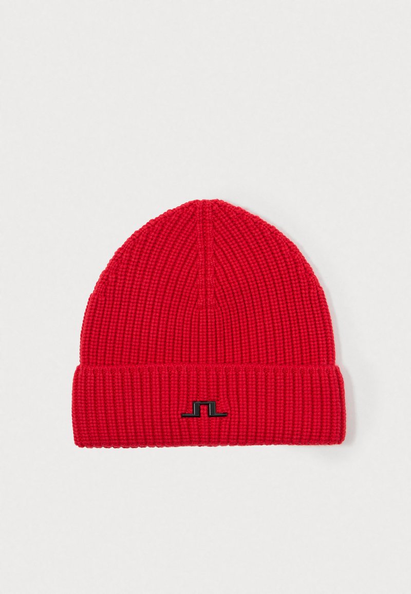 Rode geribde gebreide beanie met een omgeslagen rand, voorzien van een contrasterend zwart logo aan de voorkant. Zachte textuur en een taps toelopend ontwerp.