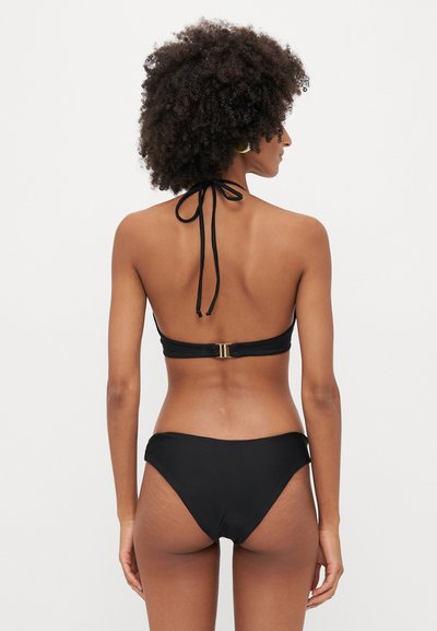 Mustaline bikiin komplekt, millel on kaelus, sooniline tekstuur ja kuldne riistvara detail taga, ning kõrge vöökoht.