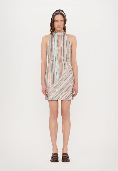 Vestido mini riscado com gola alta; cores incluem azul, rosa e bege; padrão vertical e diagonal; tecido suave; combinado com sapatos loafer escuros.