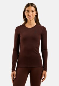 Langmouw maroon rekbaar shirt met een ronde halslijn, platte naden en een klein zwart logo op de borst. Glad en aansluitend van textuur.