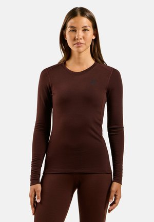Long-sleeve maroon stretchy top with a rounded neckline, flat seams, and a small black logo on the chest. Smooth and form-fitting texture.