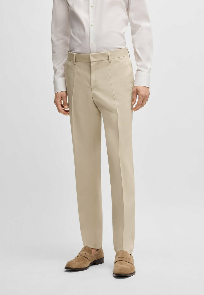 Beige tailored trousers made of smooth fabric, featuring a straight-leg cut, discreet side pockets, and a clean waistband.
