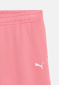 Ροζ ύφασμα με ελαστική μέση και μικρό λευκό λογότυπο Puma κοντά στο κάτω δεξιό μέρος.