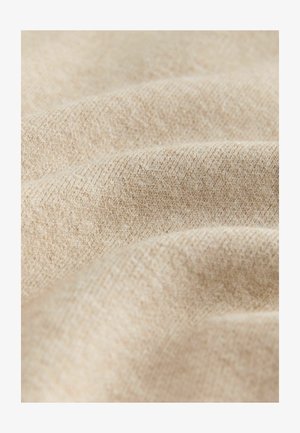 Beez värvusega tekstuuriga kangas, millel on pehme, kudumise välimus, kuvades peeneid värvi ja mustri variatsioone, rõhutades selle käega katsumise kvaliteeti.