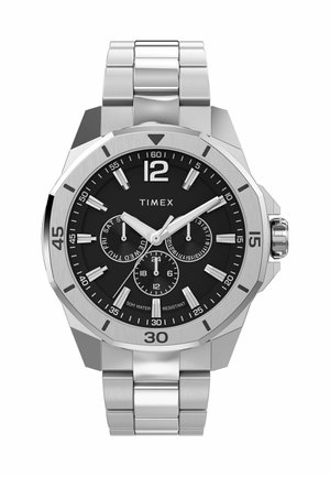 Montre en acier inoxydable argenté avec un cadran noir. Équipée de grands chiffres, de trois sous-cadrans et d'un bracelet en métal brossé. Résistante à l'eau jusqu'à 50 mètres.