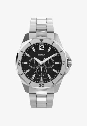 Montre en acier inoxydable argenté avec un cadran noir. Équipée de grands chiffres, de trois sous-cadrans et d'un bracelet en métal brossé. Résistante à l'eau jusqu'à 50 mètres.