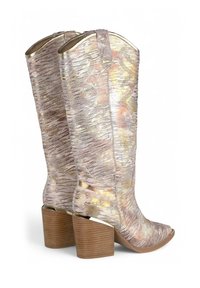 Botas de vaquero metálicas con un diseño texturizado en dorado y rosa, punta afilada y tacón de madera apilado. Cierre con cremallera en la parte trasera.