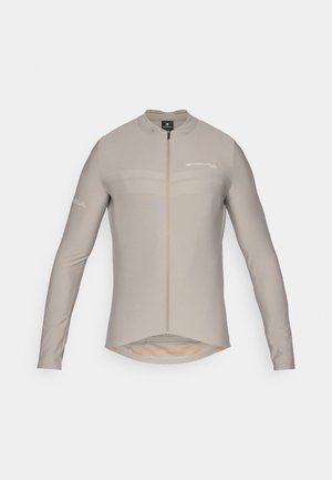 Hellbeige Radtrikot mit langen Ärmeln, hohem Kragen, Frontreißverschluss und dezenten Logodetails. Verfügt über einen verlängerten Saum und eine glatte Stofftextur.