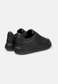 Sneakers in pelle nera con finitura liscia, punta tonda e suola bassa. Presentano un design con lacci e un logo del brand discreto sul tallone.