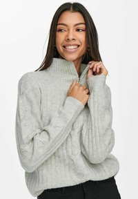 Light grey knitted sweater with a zip collar, featuring ribbed texture and cable-knit pattern on sleeves; soft fabric, relaxed fit.
