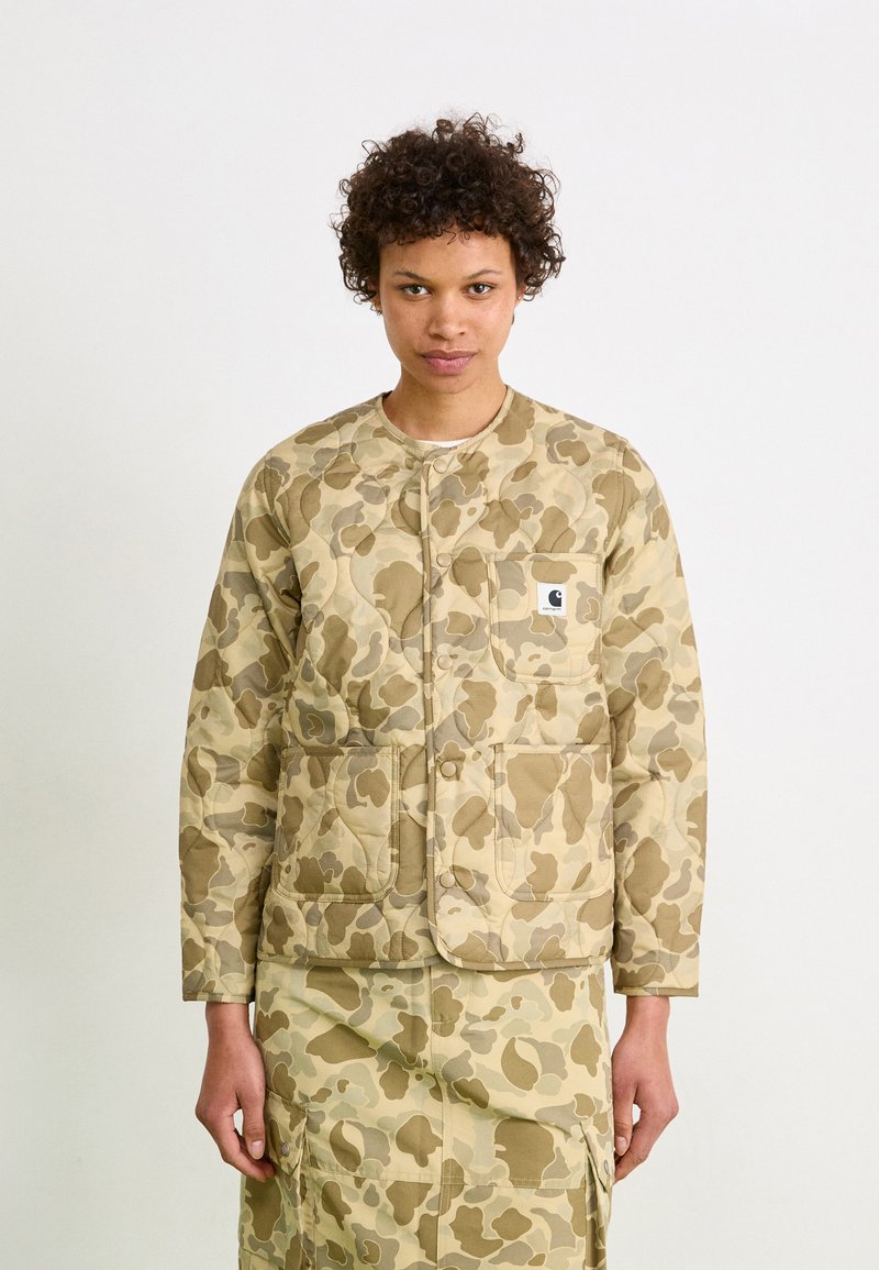Tan camouflage gevoerde jas met drukknopen, ronde hals en twee voorzakken. Bevat een bijpassende camouflage rok met vergelijkbare patronen.