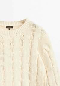 Off-white vävda tröja med rund halsringning och strukturmönster. Mjuk stickad tyg säkerställer komfort och värme.