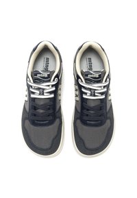 Une paire de baskets grises et marine avec des semelles blanches et des lacets de nuances claires et foncées, affichant le logo de la marque sur la languette et les panneaux latéraux.