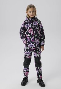 Completo giacca e pantaloni con motivo floreale, caratterizzato da uno sfondo nero con fiori viola e rosa, realizzato in materiale impermeabile e con chiusura a zip.