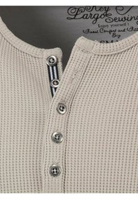 Beige wafelstof henley shirt met een vijfknopsboord met metalen knopen en een blauw-wit gestreept accent.