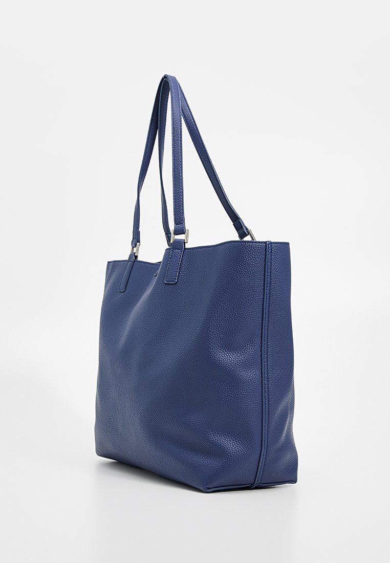 Bolso tote de piel azul marino con superficie texturizada, dos asas ajustables y diseño de apertura superior. Estructura resistente y perfil elegante.