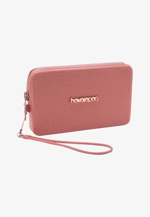 Clutch da polso rettangolare rosa con superficie strutturata, chiusura con zip e logo "havaianas" in lettere metalliche sul davanti.