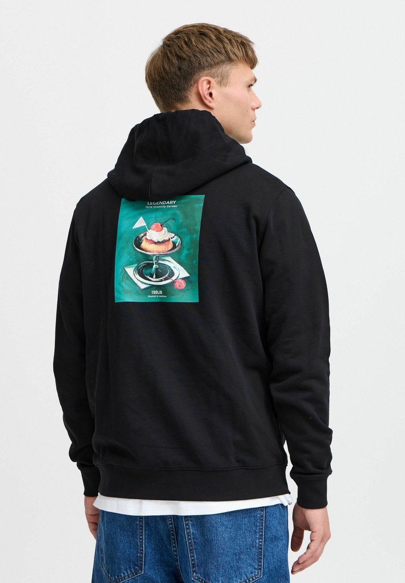 Zwarte hoodie met een grafische print op de achterkant, waarop een dessert op een bord staat, tegen een teal achtergrond. Zachte, casual pasvorm.