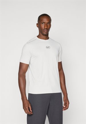 White short-sleeve athletic t-shirt with a round neckline and a small black logo on the chest. Smooth texture, fitted cut.
