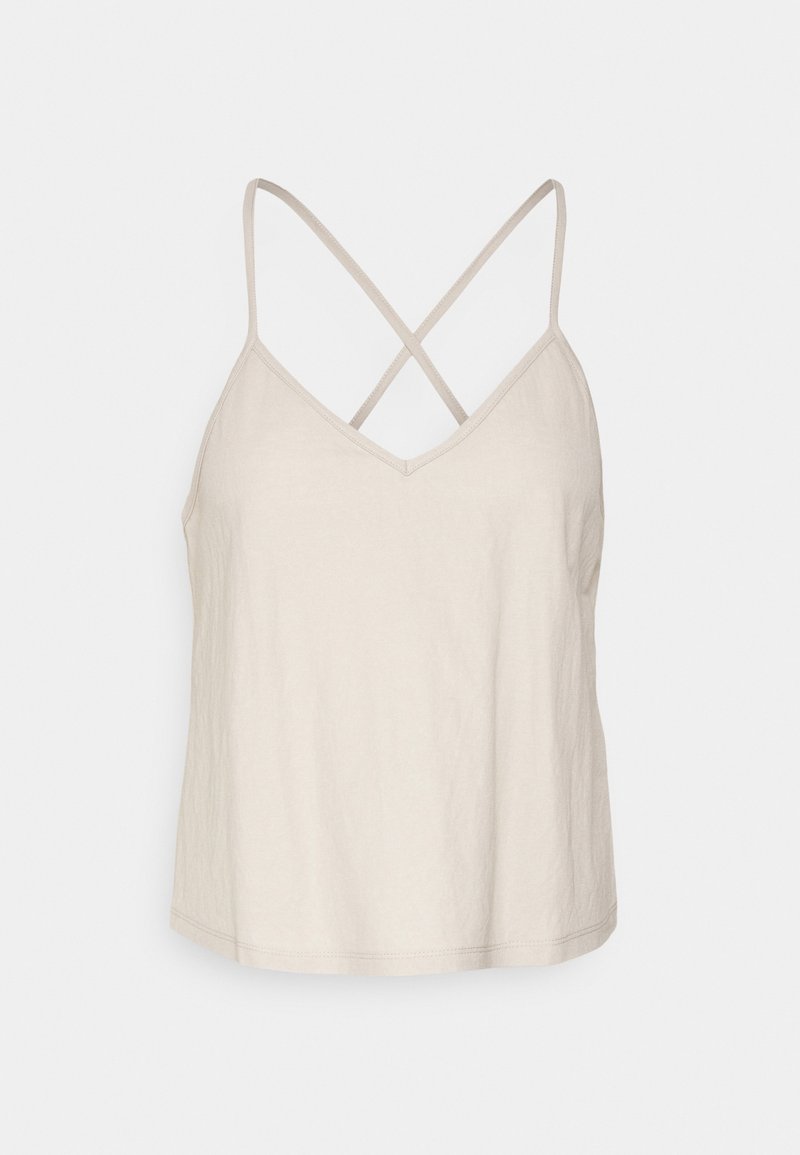 Haut femme beige sans manches avec de fines bretelles croisées dans le dos et un décolleté en V sur fond clair.