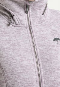 Světle fialová zipová bunda s vysokým límcem, texturovaná tkanina, kovový zip a malé černé logo deštníku.