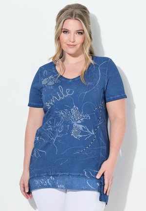Blue short-sleeve top featuring floral patterns, embellished with rhinestones, and a slightly elongated hem with side slits. Textured fabric.