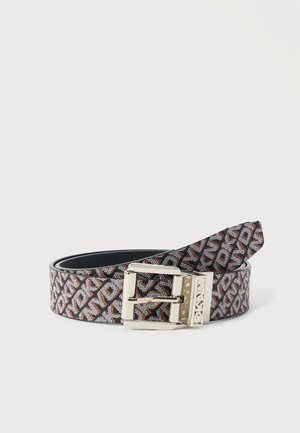 Ceinture en cuir marron et noir à motif avec boucle rectangulaire argentée et logo DKNY embossé, enroulée sur fond blanc.