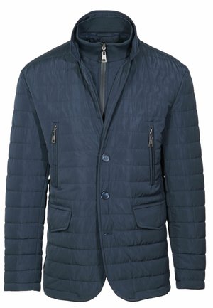 Giacca trapuntata blu navy con colletto alto, due tasche sul petto con zip e bottone frontale. Texture liscia con dettagli di cucitura minimi.