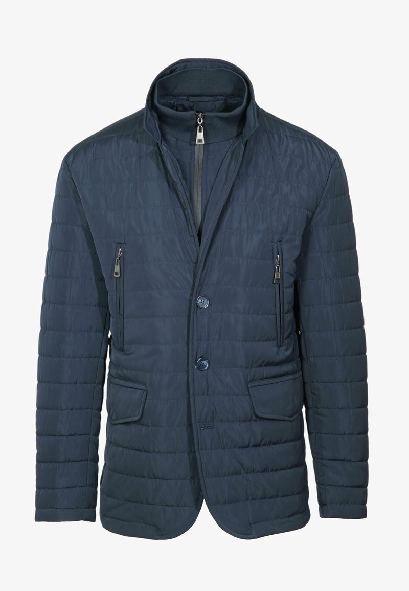 Giacca trapuntata blu navy con colletto alto, due tasche sul petto con zip e bottone frontale. Texture liscia con dettagli di cucitura minimi.