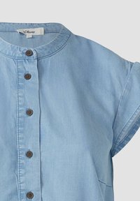 Helles blaues Chambray-Hemd mit Rundhalsausschnitt, kurzen Ärmeln und braunen Knöpfen an der Vorderseite. Glatte Textur mit lässigem Schnitt.