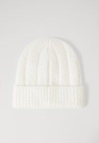 Bonnet en tricot blanc avec une texture côtelée, présentant un rebord replié et des lignes verticales le long du corps. Tissu doux et chaud.