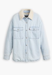 Lys blå denimjakke med en beige faux fur-krage, to frontlommer med klaff og knappelukkinger langs fronten og mansjettene.